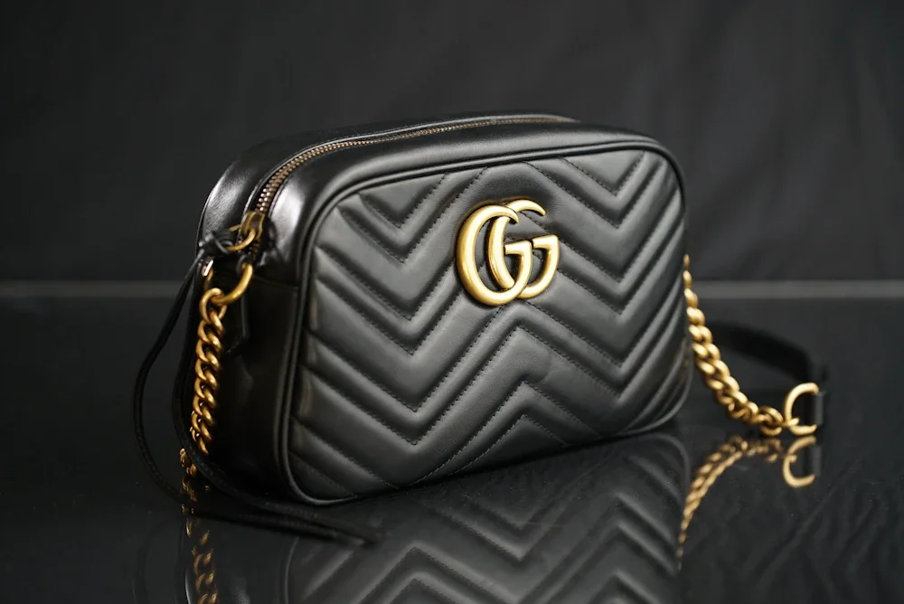 Structured architectural leather shoulder bag with defined geometric silhouette on minimal display