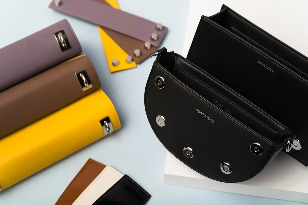 Half-moon shaped leather bags in multiple colorways including black, mauve, and yellow — showing the silhouette range available for wholesale